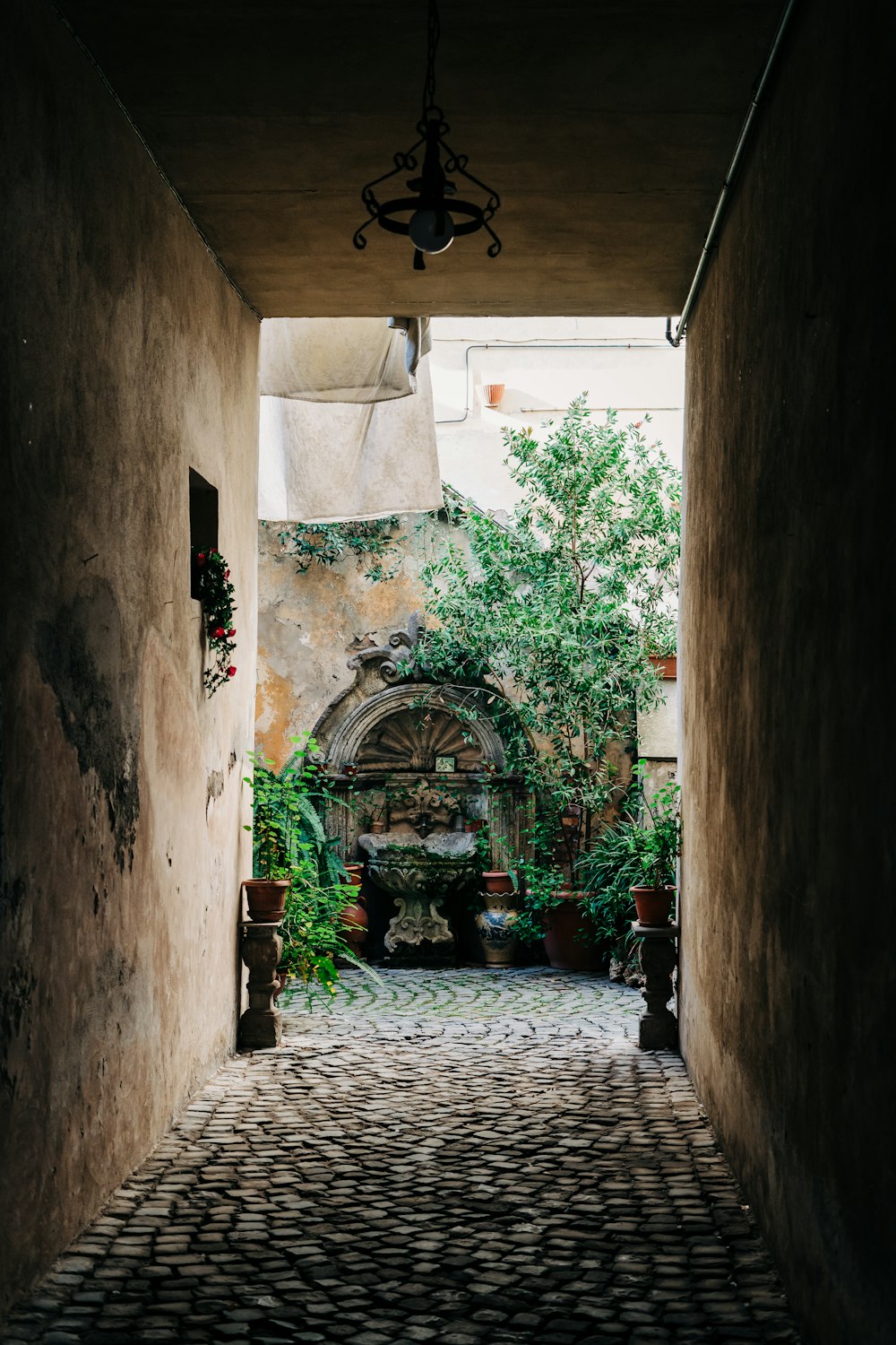 an alley way with a lamp hanging from the ceiling