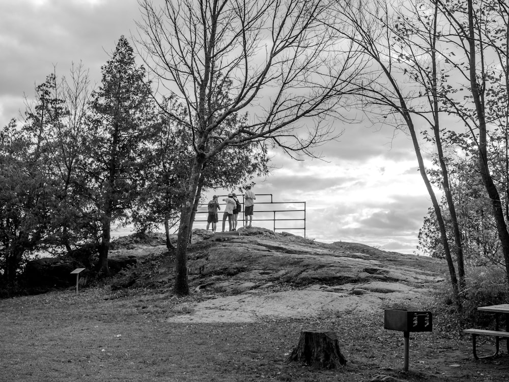 a black and white photo of a man standing on top of a hill