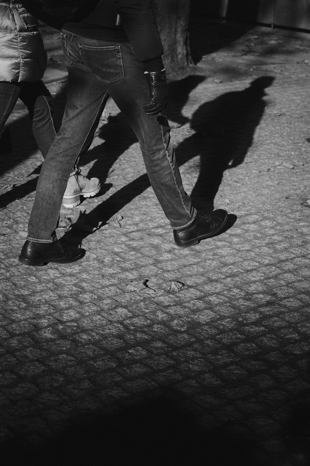 a black and white photo of people walking down the street