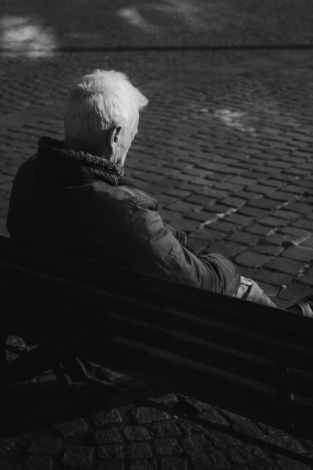 a person sitting on a bench in a park