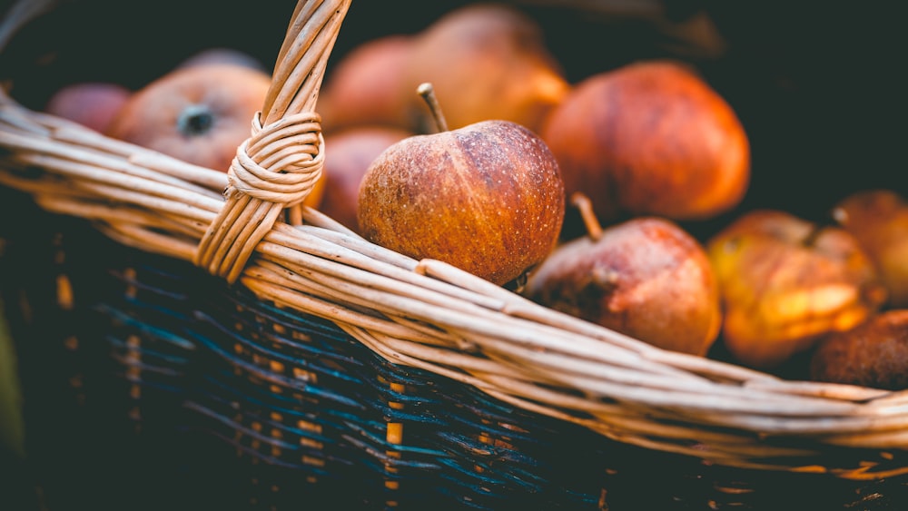 a basket filled with lots of ripe apples