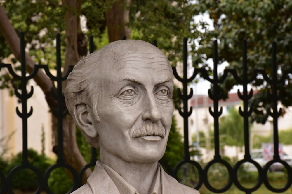 a statue of a man in front of a fence