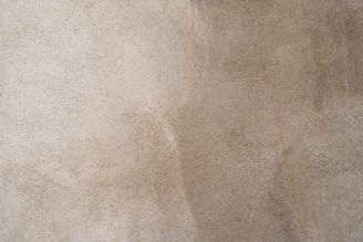 A beige and tan wall with a rough plaster texture