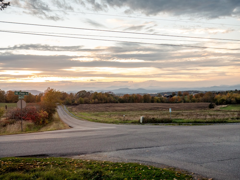 a rural road with a stop sign on the corner