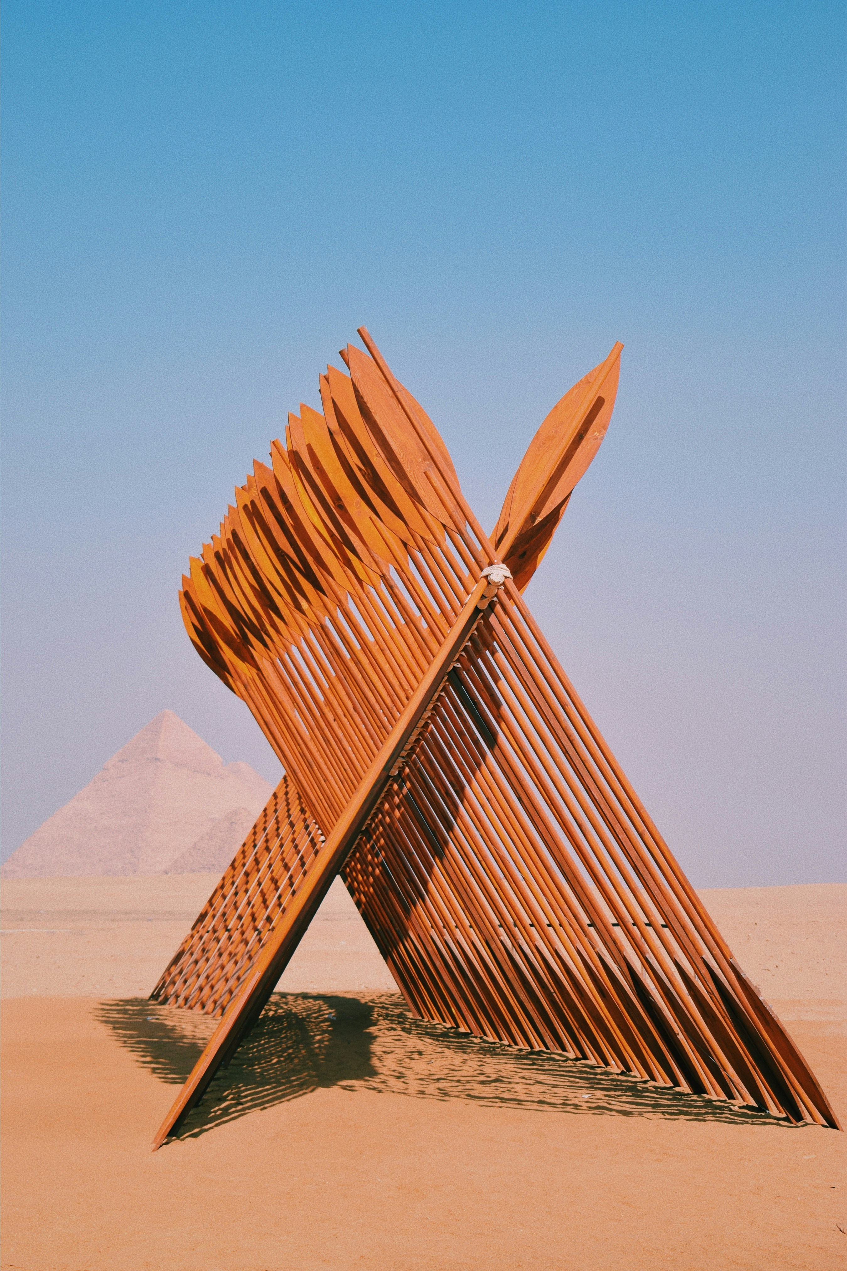 An art piece with the pyramids of giza in the background.