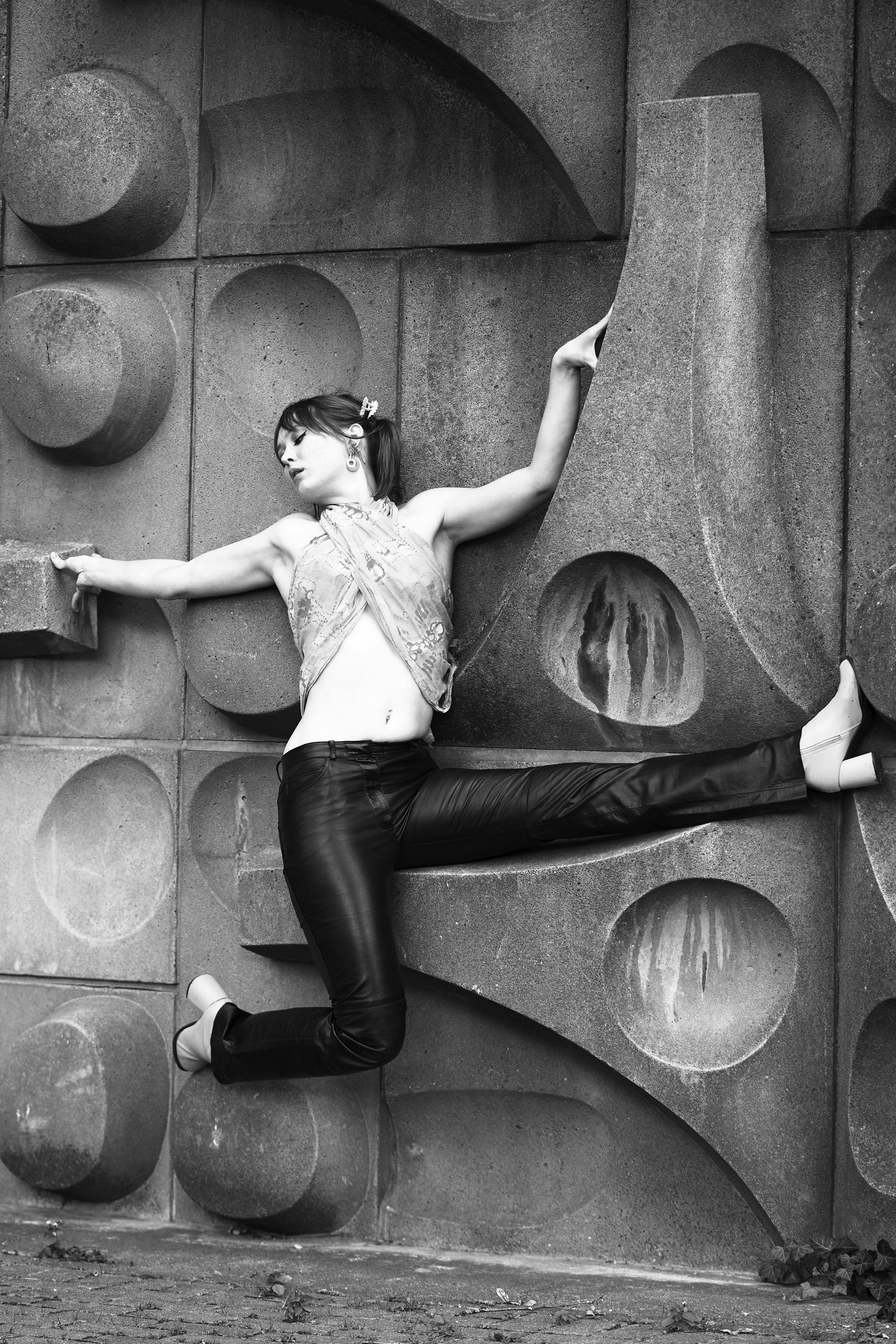 a woman is posing in front of a sculpture