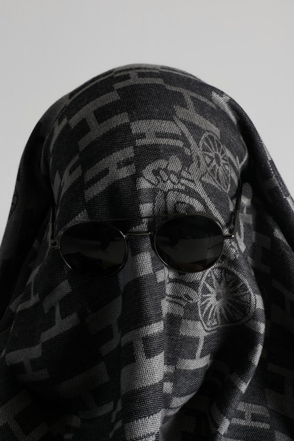 a person wearing sunglasses and a scarf