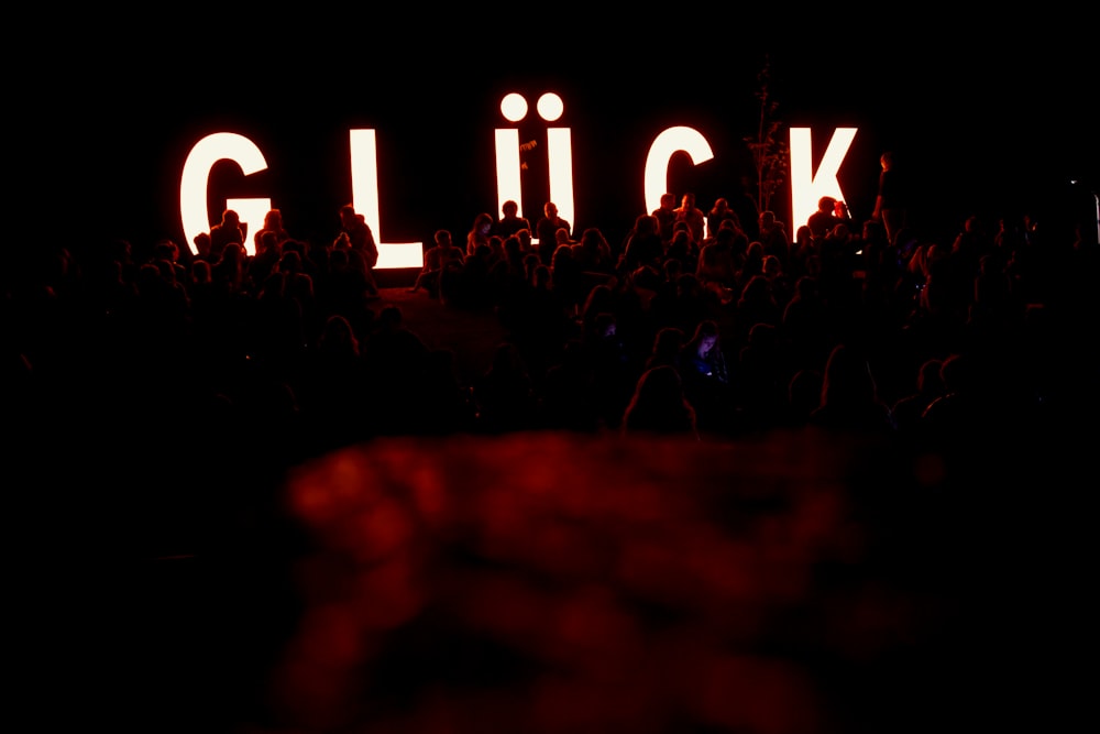 a crowd of people standing in front of a sign