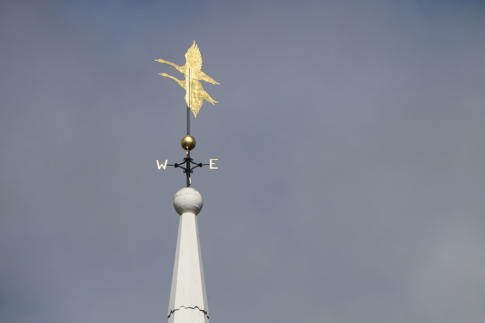 a weather vane on top of a white building