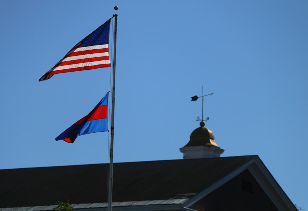 two flags flying in front of a church steeple