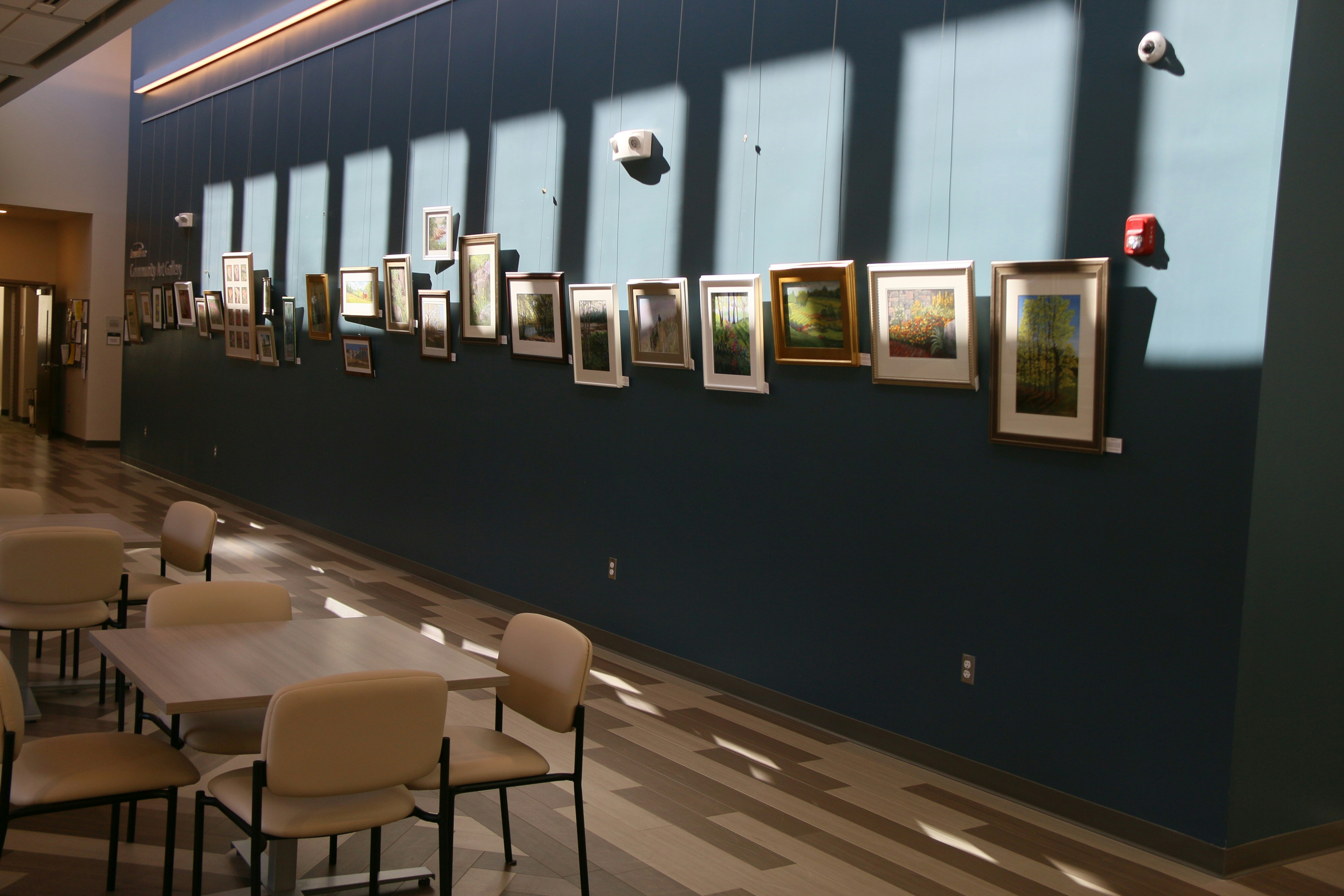 a room filled with tables and chairs next to a wall