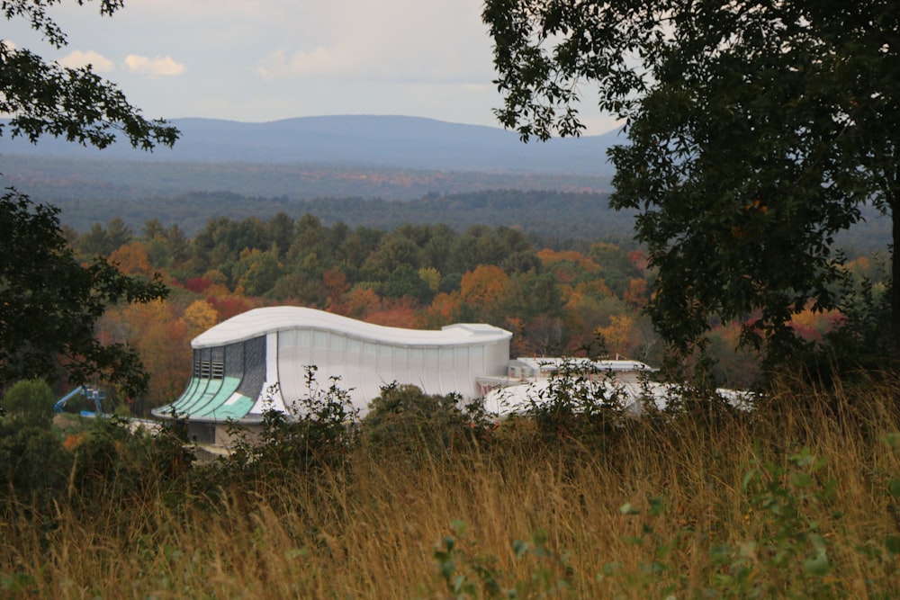 a building in the middle of a field with mountains in the background