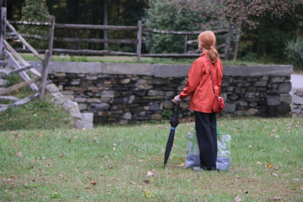 a woman standing in a field holding an umbrella