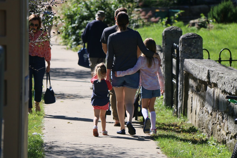 a group of people walking down a sidewalk