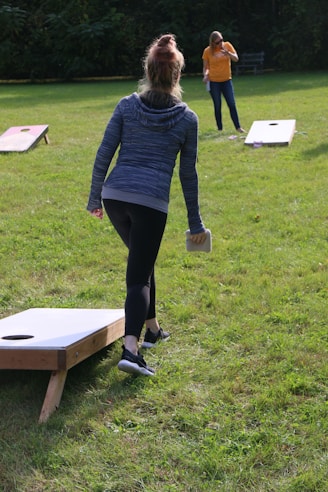 two women playing a game of bean bag toss