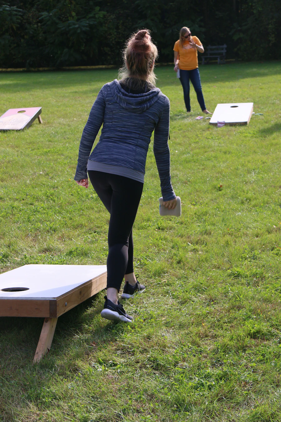 Friends playing a bean bag toss game outdoors