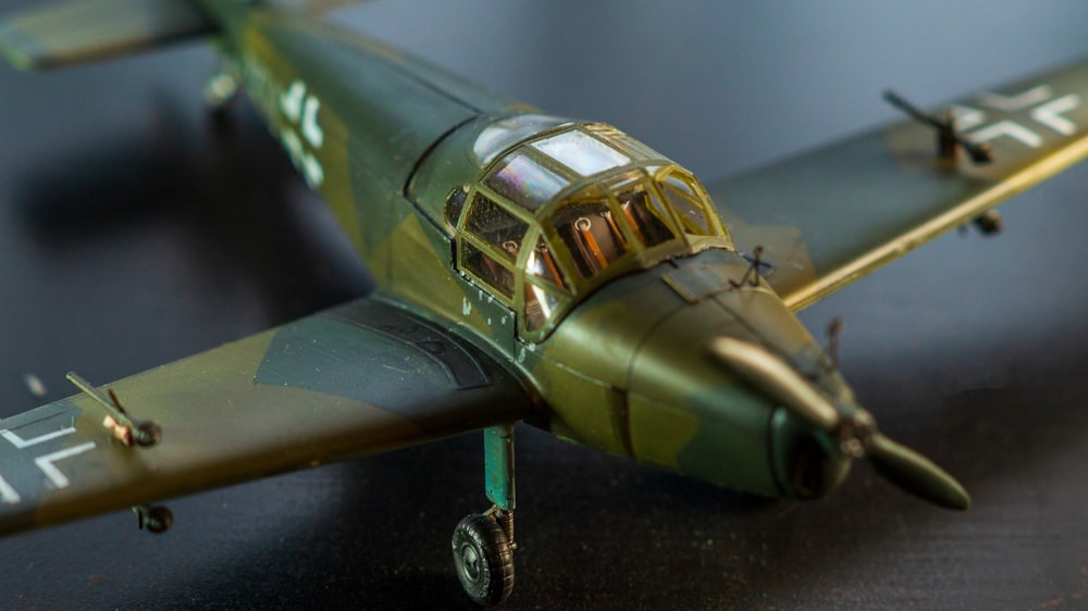 a green model airplane sitting on top of a table