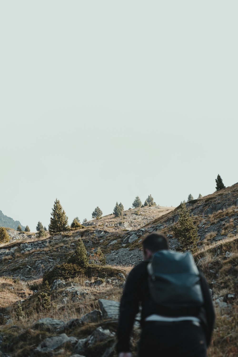 a man with a backpack walking up a hill