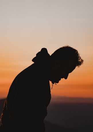a man standing in front of a sunset