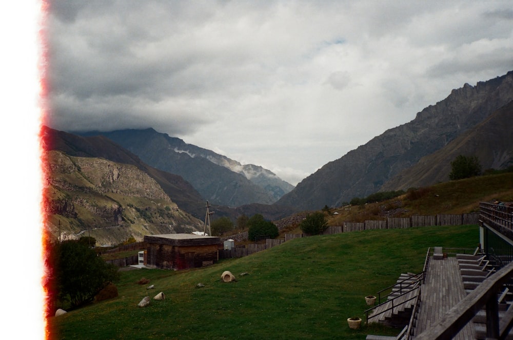 a grassy field with mountains in the background