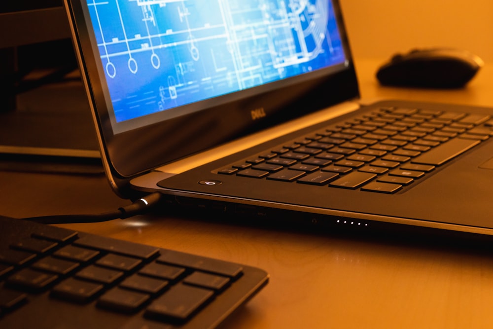 a laptop computer sitting on top of a wooden desk