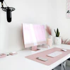 a white desk with a pink computer on it