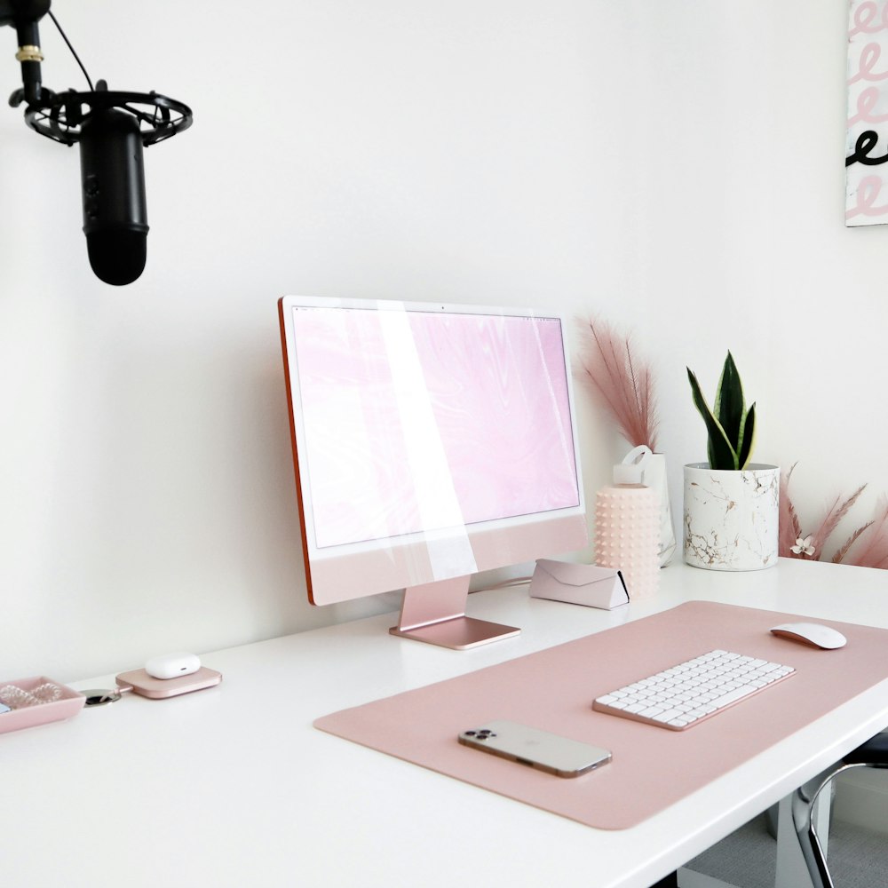 a white desk with a pink computer on it