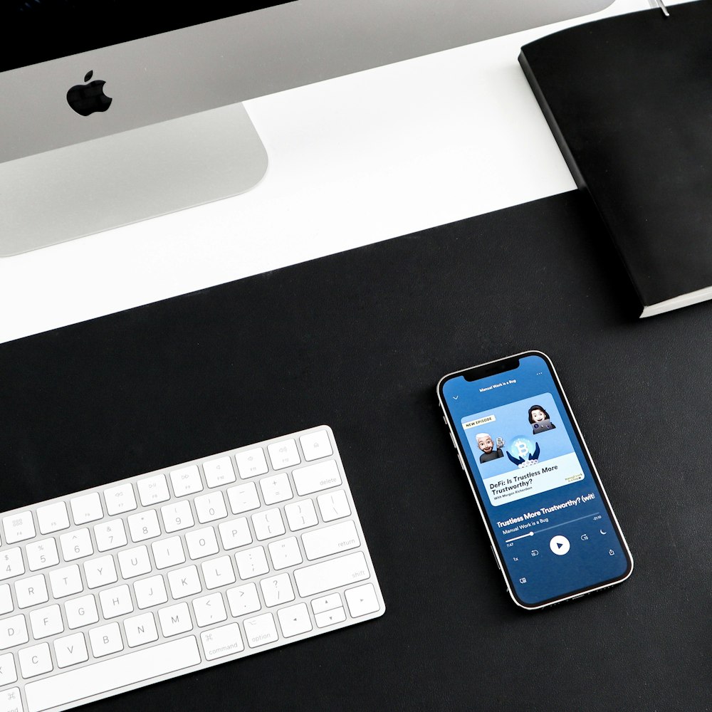 a cell phone sitting on top of a desk next to a keyboard