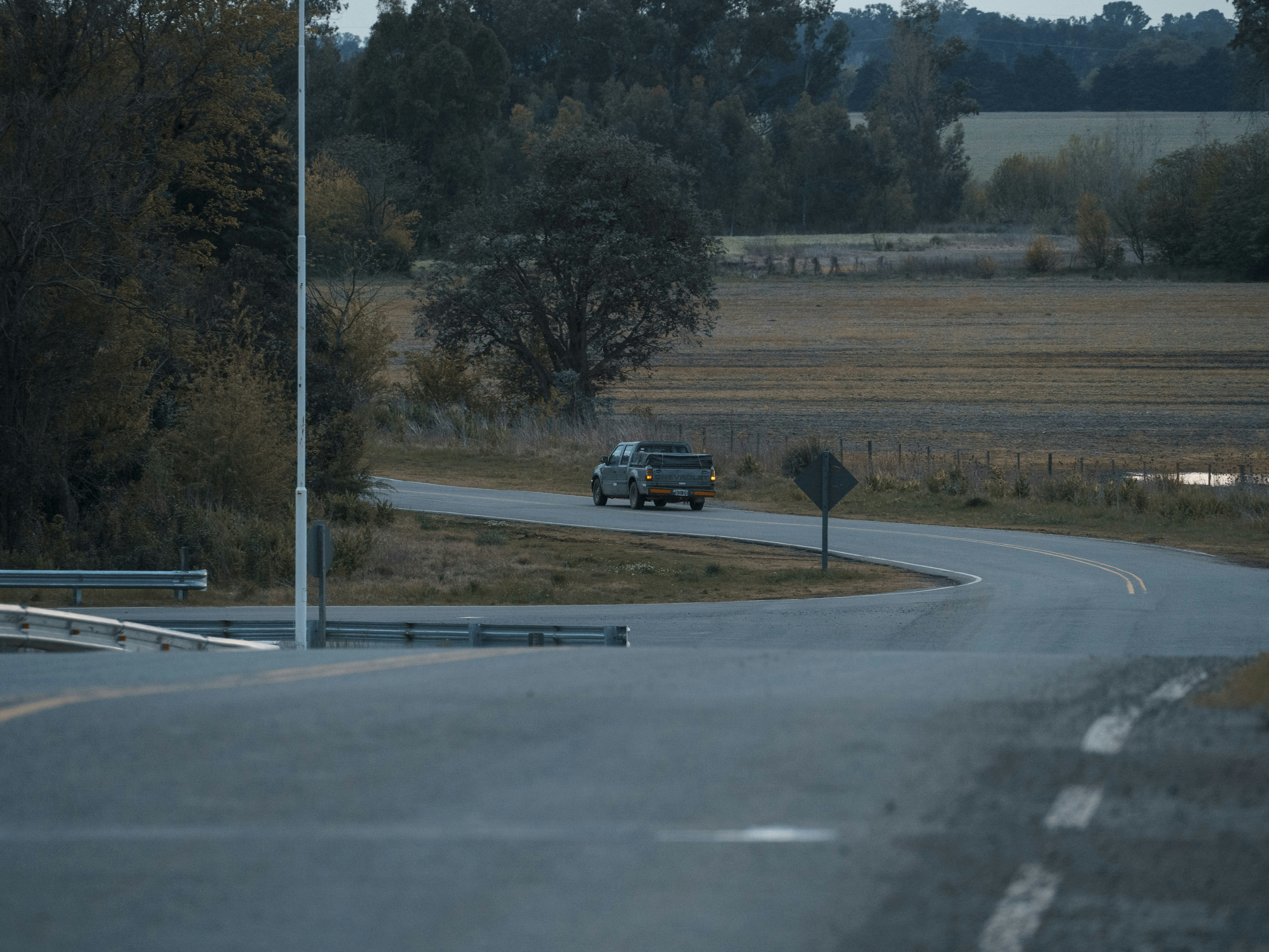 a truck driving down a curvy road in the country