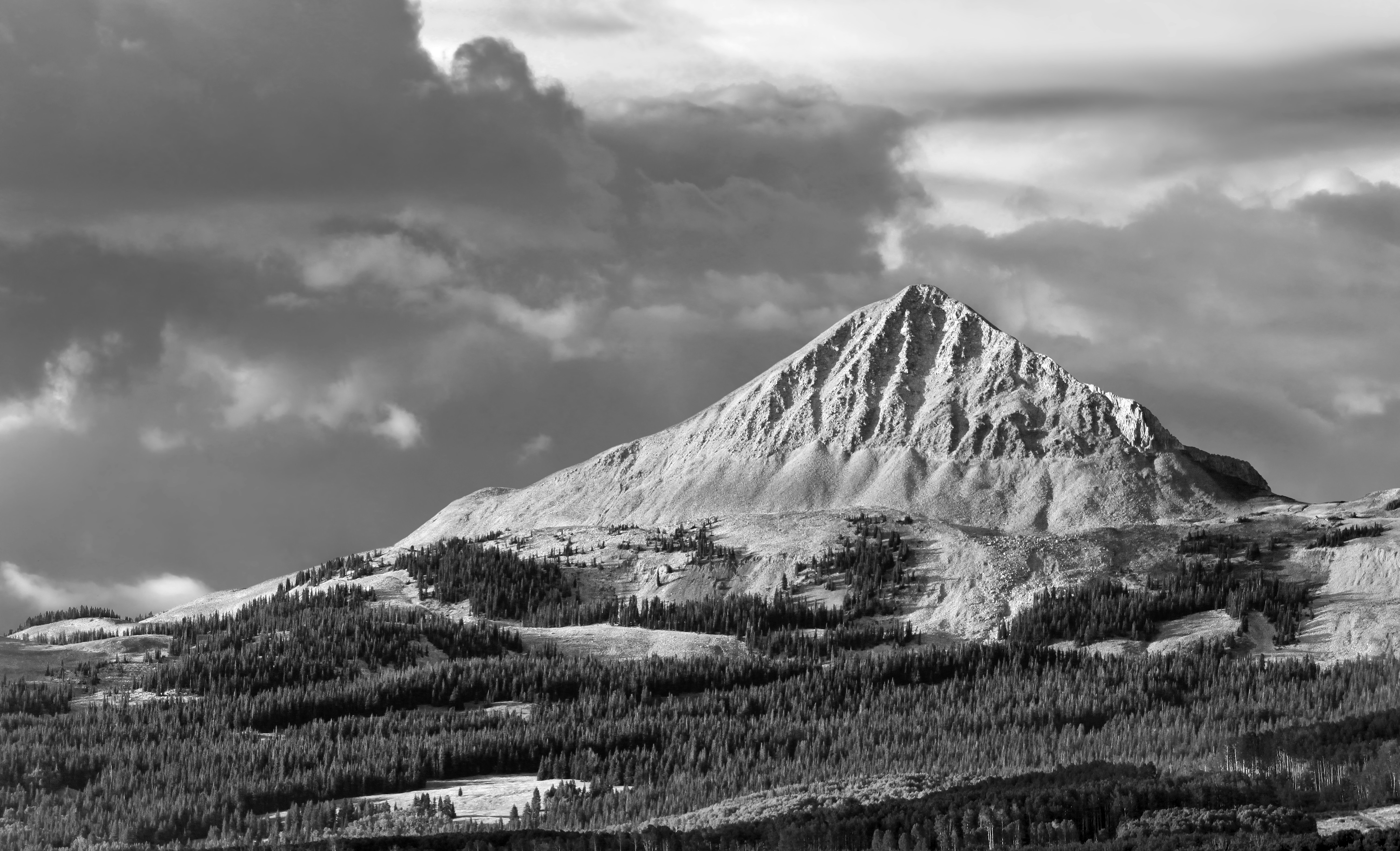 a black and white photo of a snow covered mountain