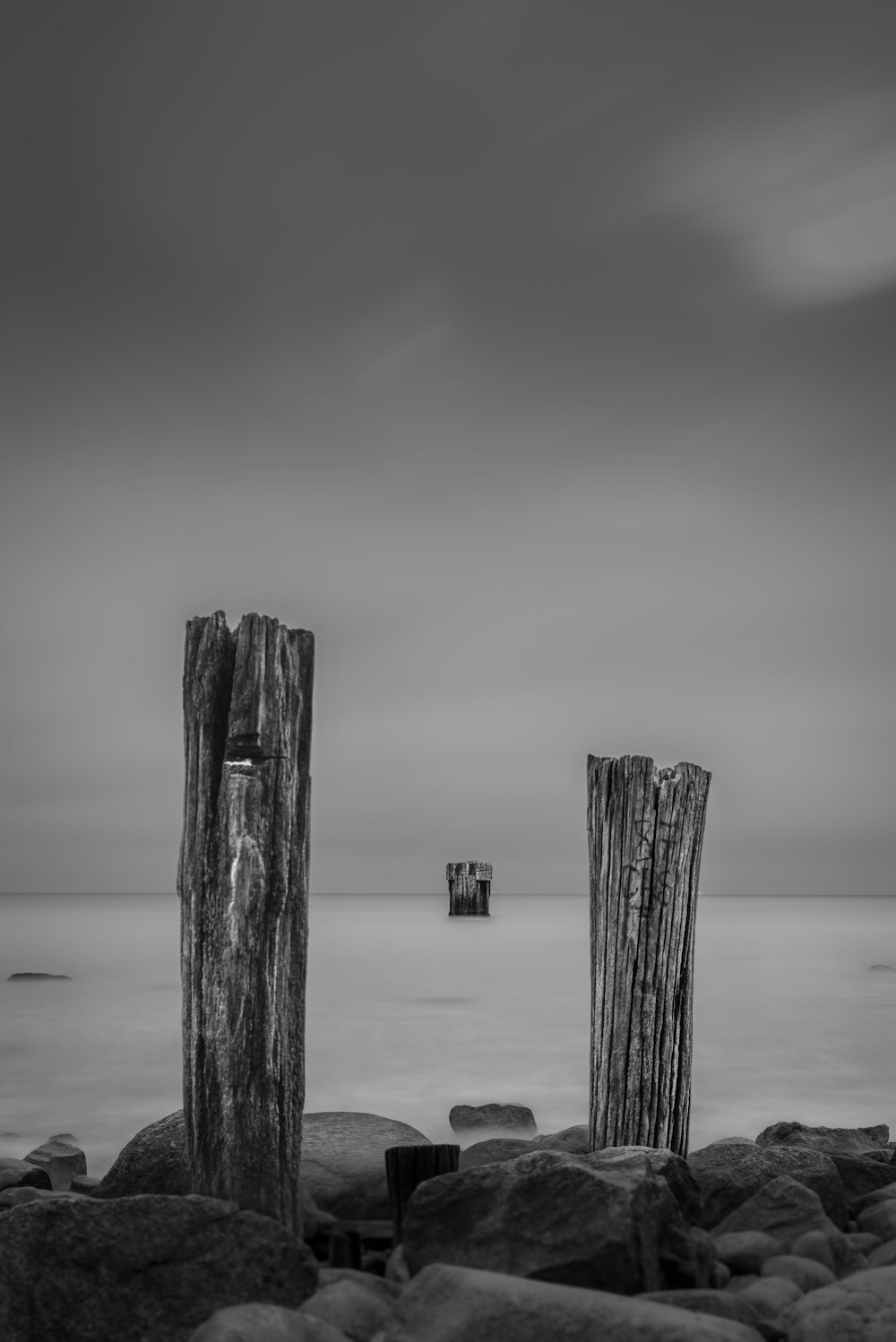 two wooden posts sticking out of the water