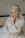 a woman in a wedding dress sitting on a bed