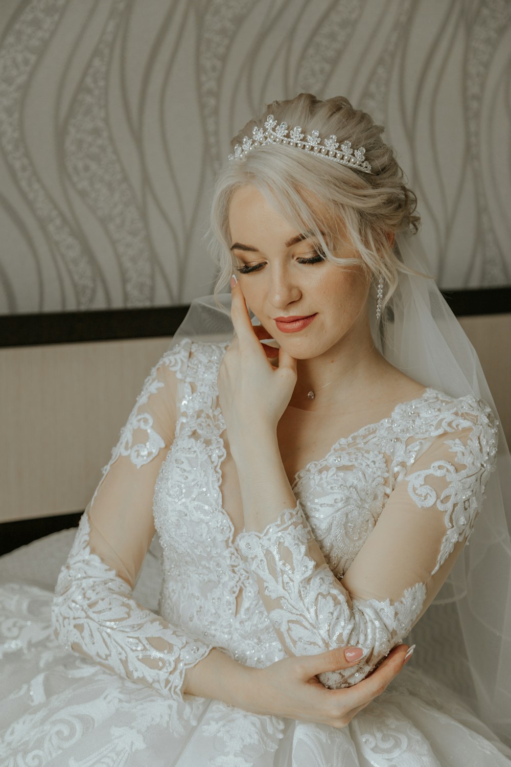 a woman in a wedding dress sitting on a bed