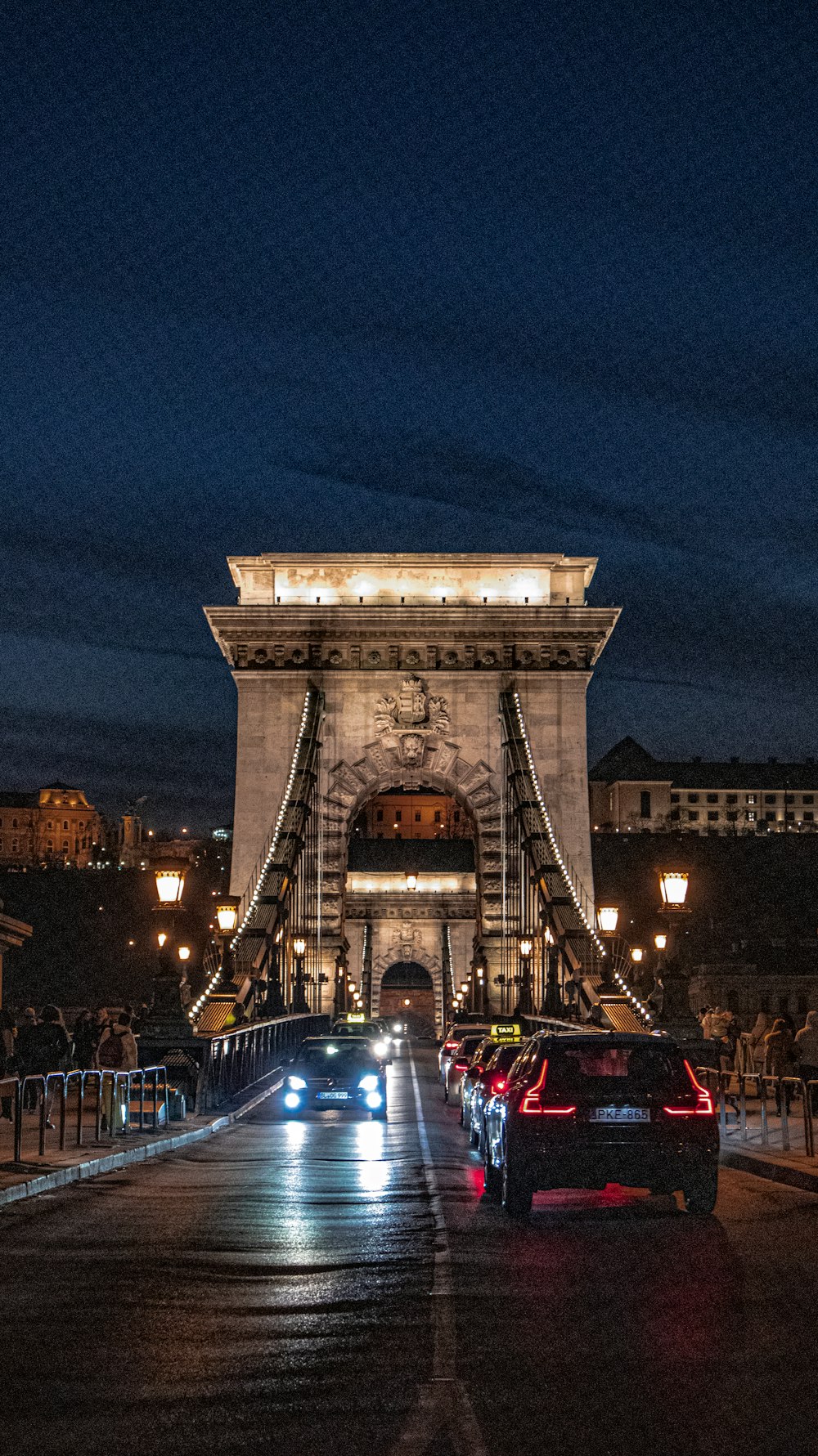 cars drive across a bridge at night in the city