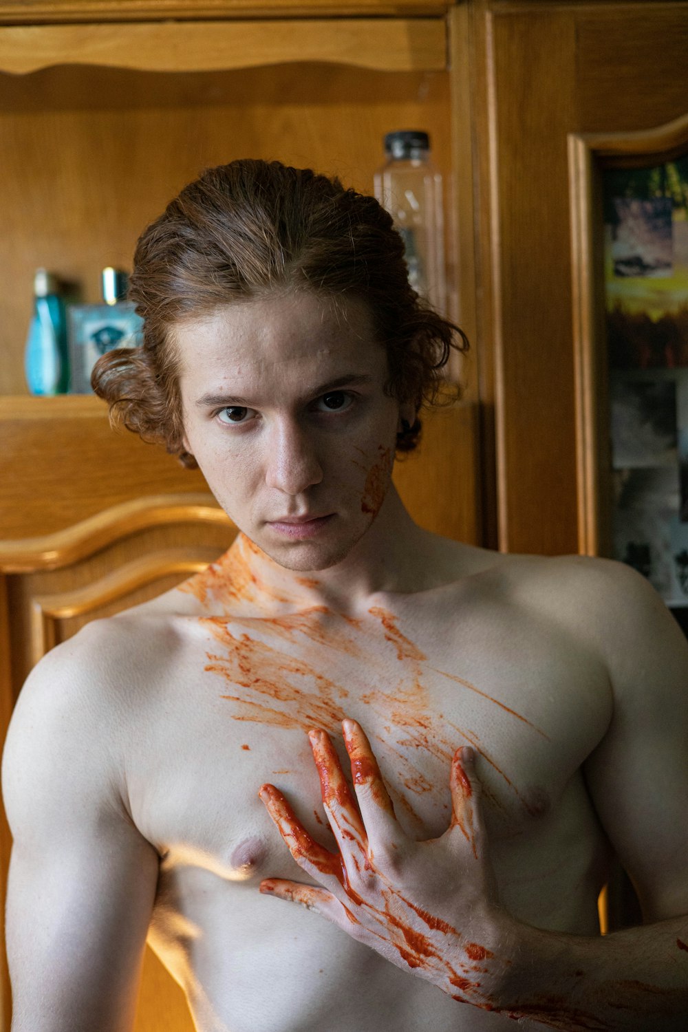 a shirtless man with his hands covered in blood