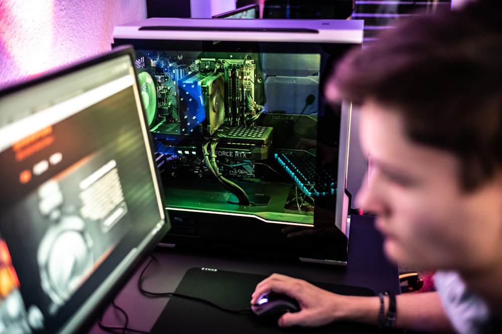 a man sitting in front of a computer monitor