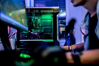 a man sitting in front of a computer monitor