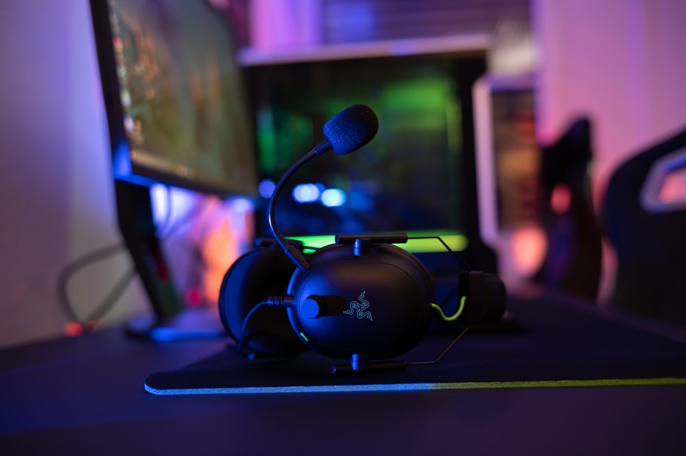 a computer desk with a mouse and headphones on it