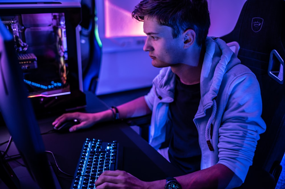 Un hombre sentado frente al teclado de una computadora