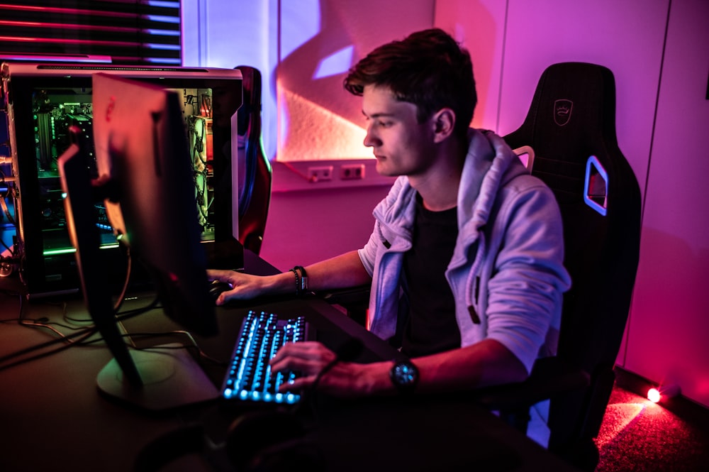 Un hombre sentado frente al teclado de una computadora