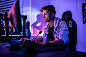 Close-up shot of a gaming PC setup with glowing neon purple accents and a comfortable chair.