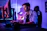 A focused gamer stretching with a bright, modern gaming setup in the background.