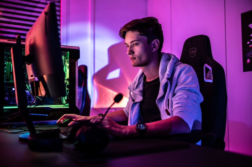 a man sitting at a desk with a computer in front of him