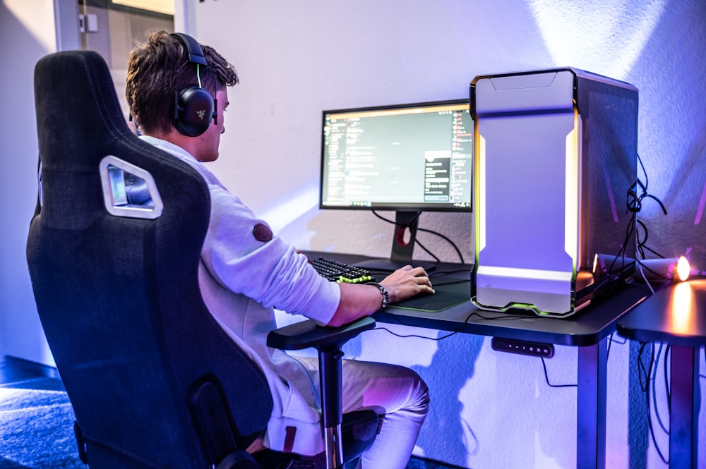 a man sitting in front of a computer on a desk