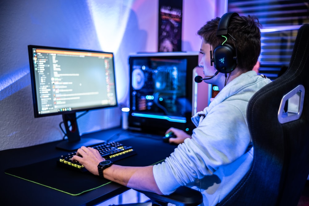 a man wearing a headset sitting at a computer desk