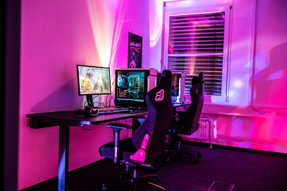 a desk with a computer and a gaming chair