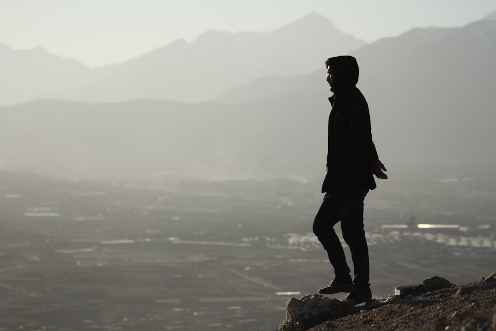 a man standing on top of a rocky hill