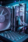 A close-up view of the interior of a computer, highlighting RAM modules and a cooling fan. The system's cables and components are neatly organized, and the lighting gives a futuristic, high-tech feel.