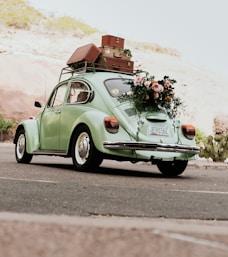 a green car with luggage on top of it
