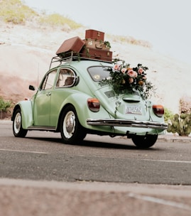 a green car with luggage on top of it